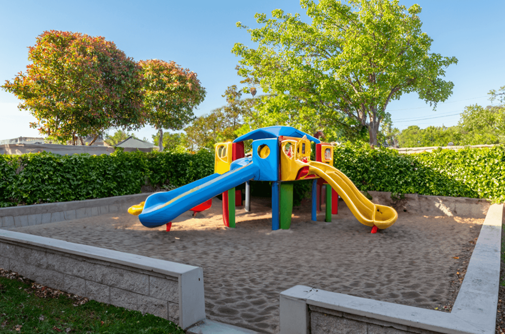 A colorful playground with a blue and yellow slide.