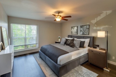 A bedroom with a large bed and a ceiling fan.