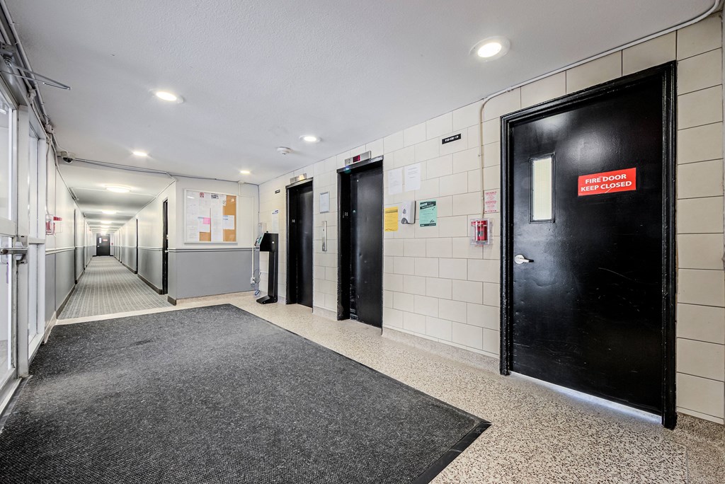 A hallway with a red sign on a door that says "Fire door closed".