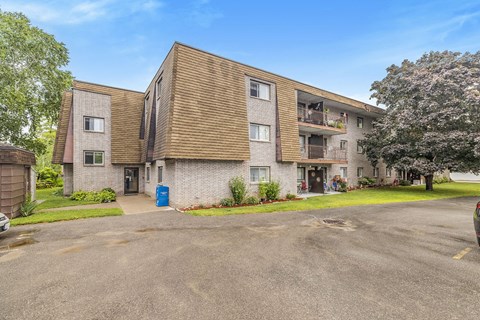 A large apartment complex with a parking lot in front.