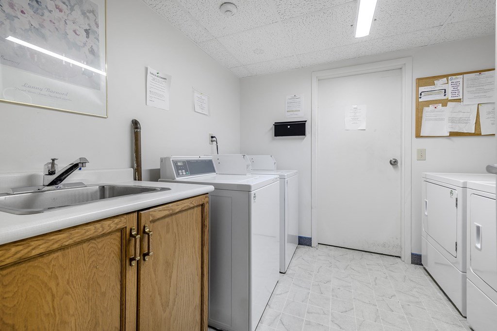 A clean, white-walled laundry room with a washer and dryer.