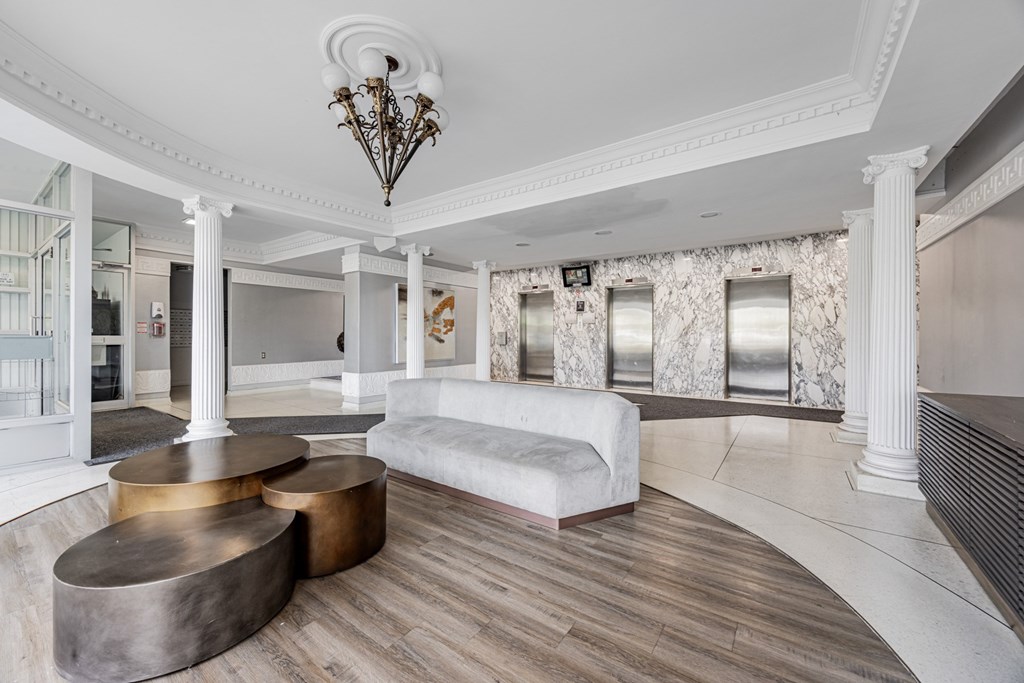 A white room with a large circular table and a chandelier.
