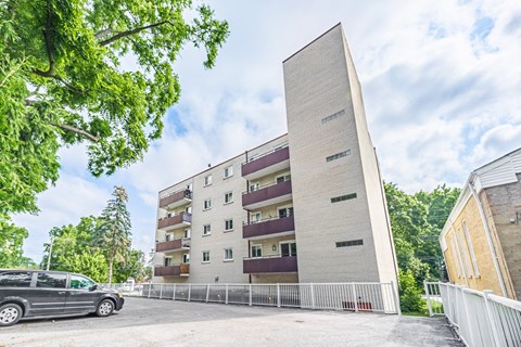 A modern building with a white facade and a tall rectangular section on the right side.