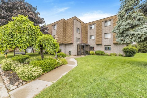 A building with a green lawn in front.