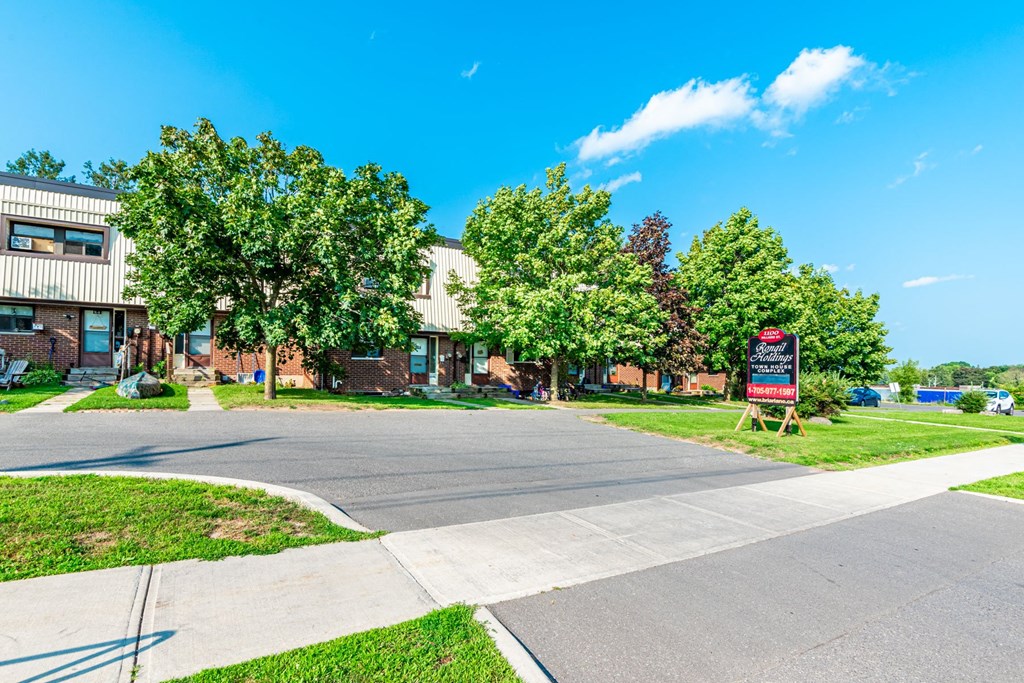 A sunny day at a residential area with a road and houses.