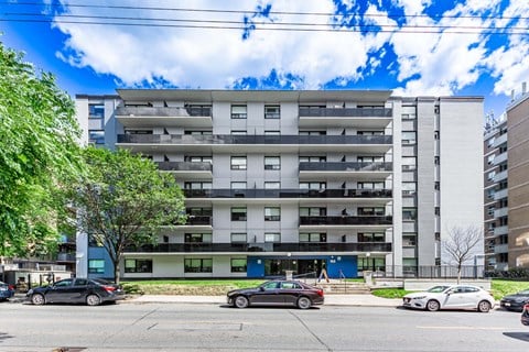 A large white apartment building with a blue door in front.