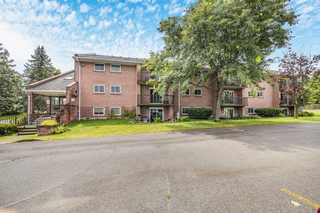 a large brick apartment building with a tree in front of it
