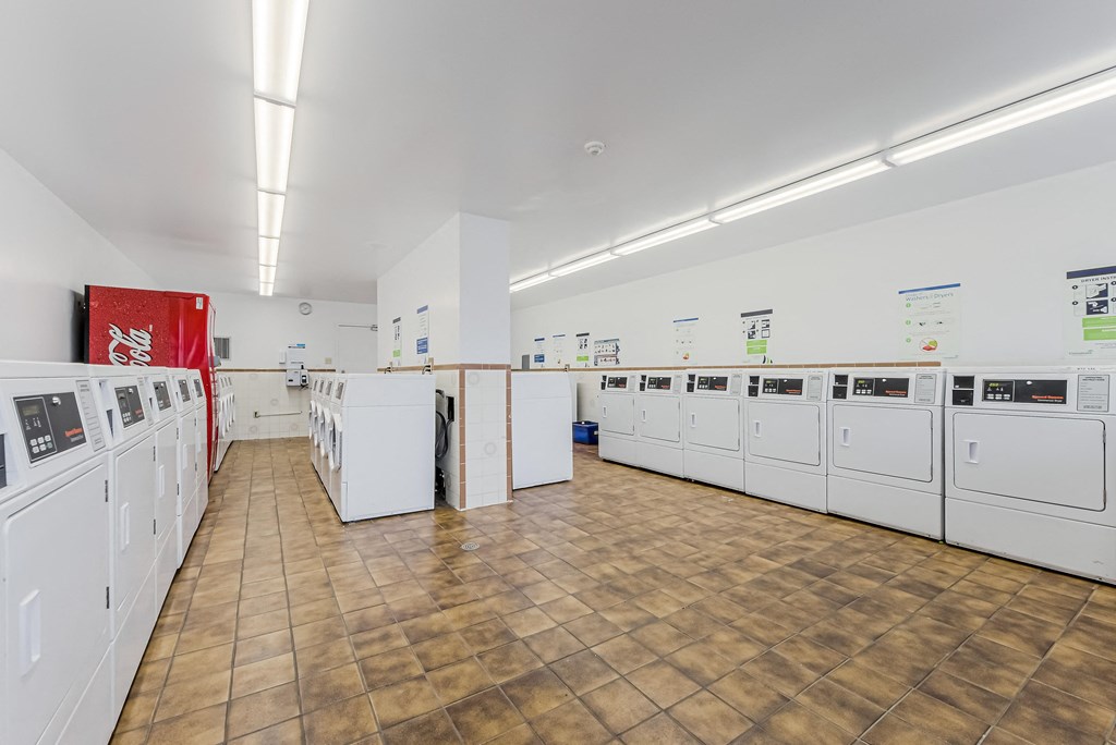 a washer and dryer room in a building with whitewashes in it