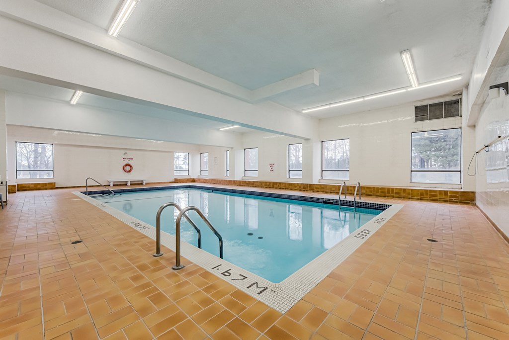 A large indoor swimming pool with tiled floors and walls.