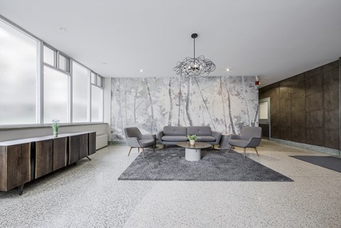 A modern living room with a grey sofa set and a large window.