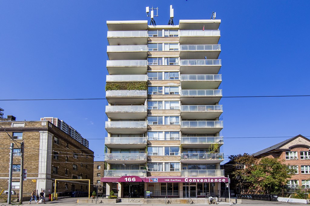 A tall building with a green plant on the side and a sign that says Convenience.