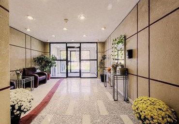 A hallway with a red carpet and a white tile floor.