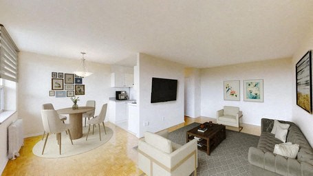 A living room with a grey couch, a white chair, a brown table and a television.