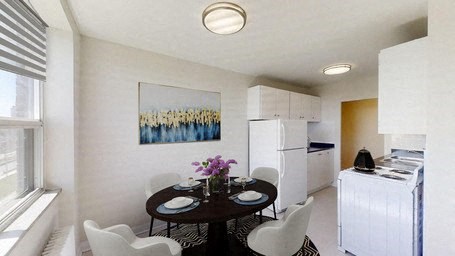 A dining room with a table set for two and a painting on the wall.