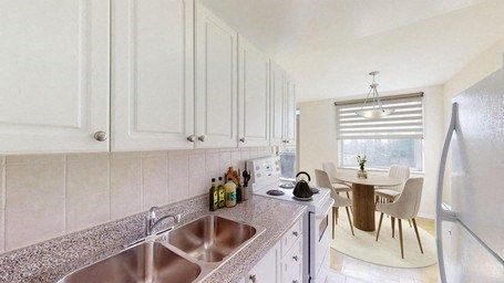 A kitchen with white cabinets and a granite countertop.