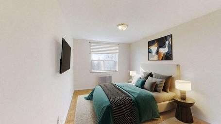 A bedroom with a bed, a nightstand, and a television.