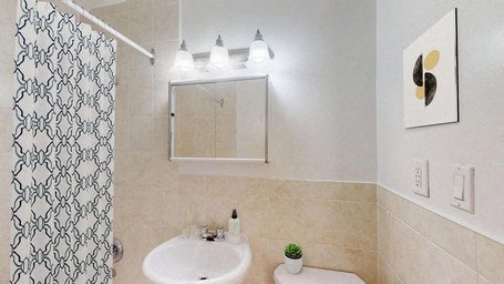 A bathroom with a white sink and a patterned shower curtain.