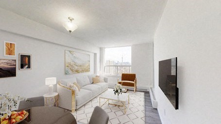 A living room with a couch, chairs, a coffee table, and a television.