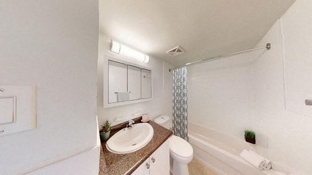 A white bathroom with a sink, toilet, and bathtub.