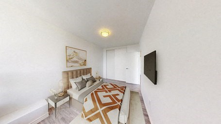 A bedroom with a bed, a nightstand, and a painting on the wall.