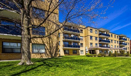 Apartment building with a tree in front of it.