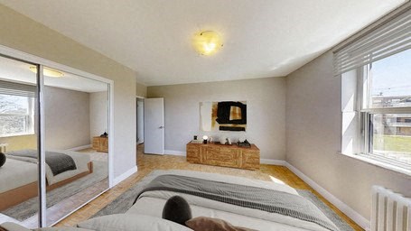 A bedroom with a large bed and a wooden bench in the middle of the room.