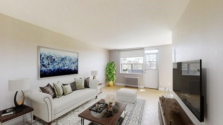 A living room with a white couch and a painting on the wall.