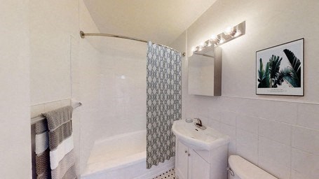 A white toilet sits next to a white sink in a bathroom.