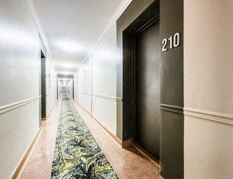 A hallway with a door numbered 210 on the right.