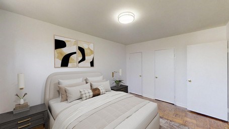 A bedroom with a bed, nightstand, and artwork on the wall.