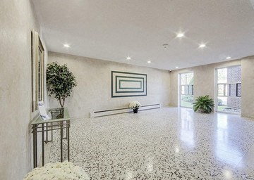 A spacious room with a marble floor and a framed picture on the wall.