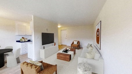 A living room with a white couch and a television.