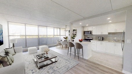 A modern living room with a glass table and white chairs.