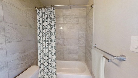 A white bathtub with a shower curtain in a bathroom.