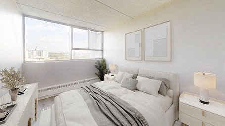 A white bedroom with a large bed and a window overlooking a cityscape.