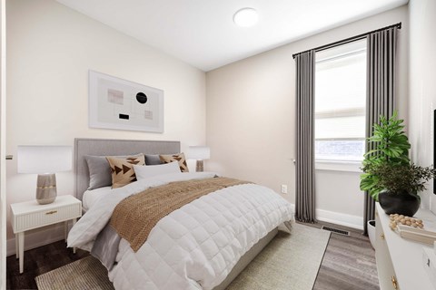 A bedroom with a large bed and a window with curtains.