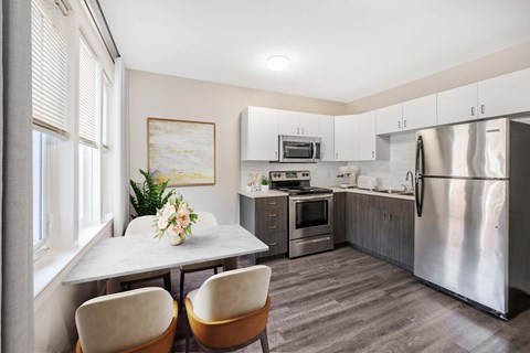 A kitchen with a table and chairs by the window.