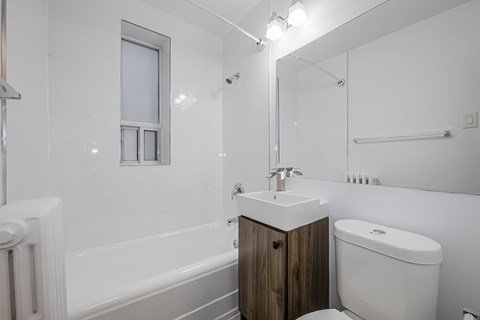A white bathroom with a sink, toilet, and bathtub.