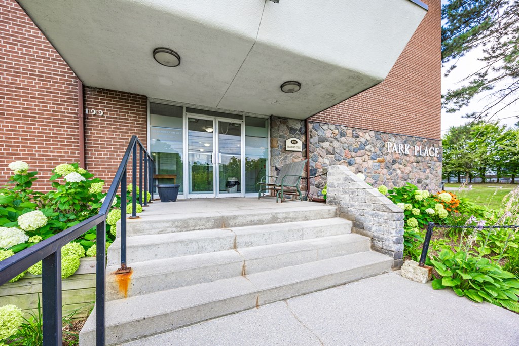 a building with stairs and a glass door and a stone facade