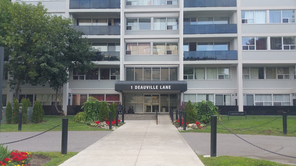 The entrance to a building named 1 Deaulille Lane is surrounded by a well-maintained garden.