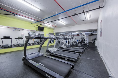 A gym with treadmills and other exercise equipment.