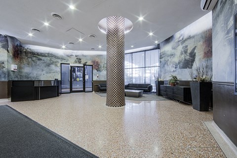 A modern office lobby with a large column in the center.
