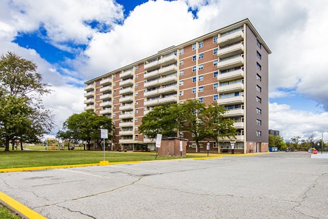 A large apartment building with a parking lot in front.