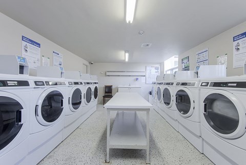 A laundromat with a row of washers and dryers.