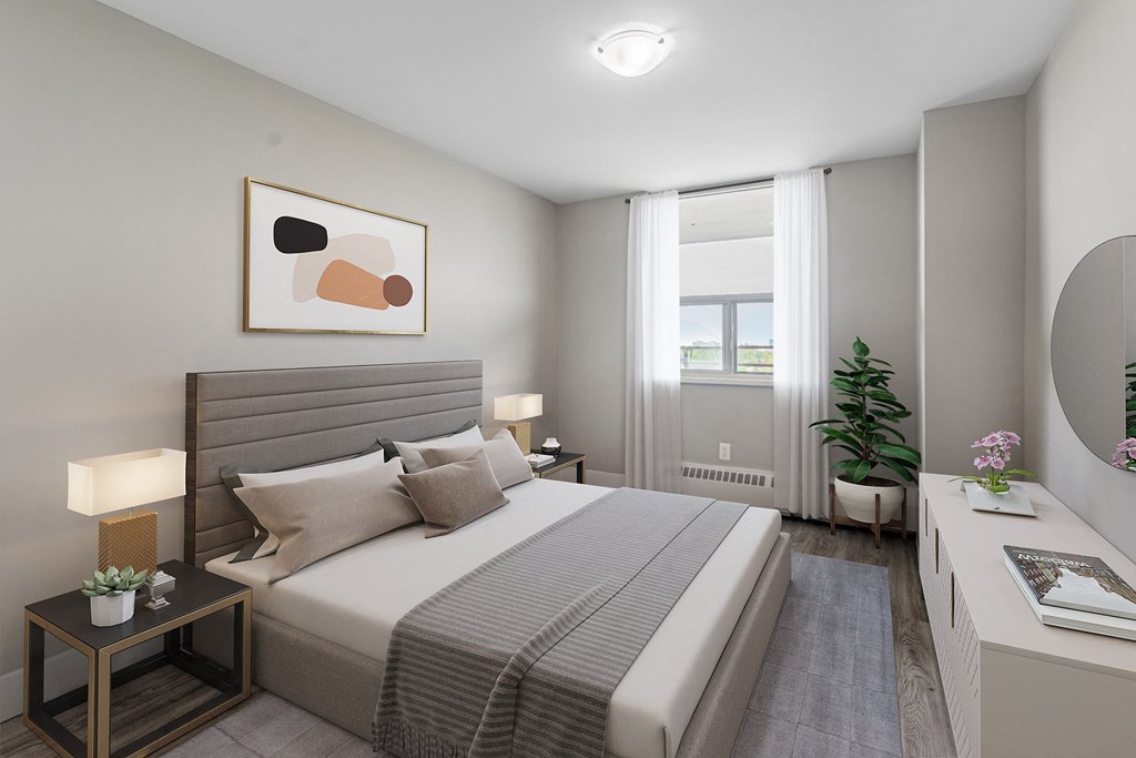 A well-lit bedroom with a large bed and a painting on the wall.