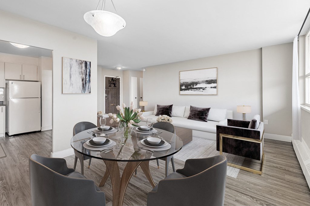 A modern dining room with a glass table and grey chairs.