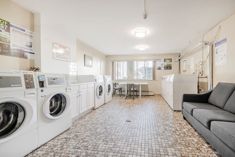 A laundry room with washing machines and a couch.