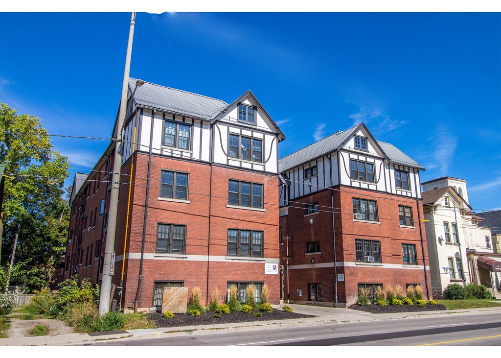 A red brick building with white trim and a black roof.