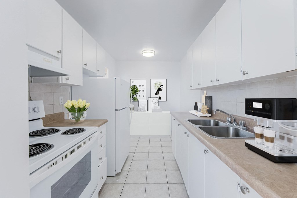a white kitchen with a stove and a sink