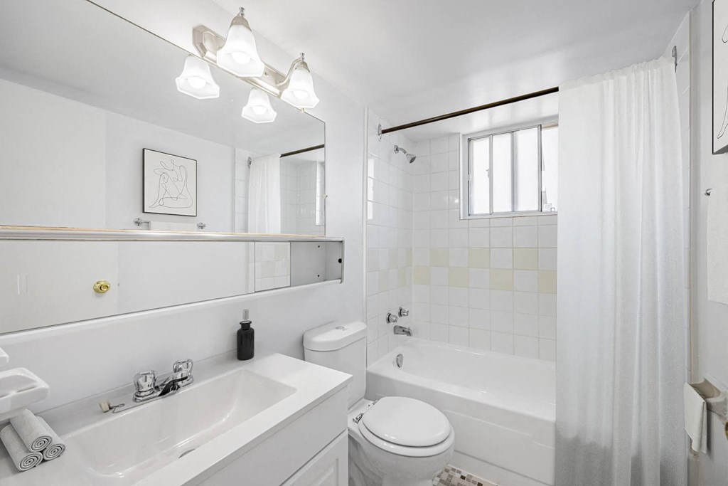 A white bathroom with a sink, toilet, and bathtub.